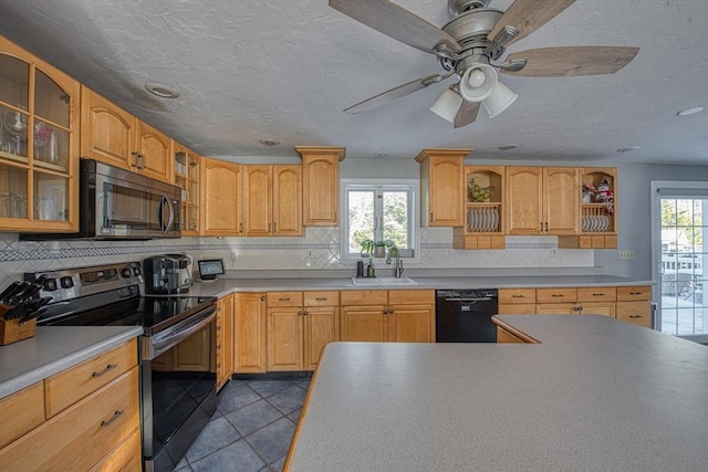 kitchen with sink, a healthy amount of sunlight, light tile patterned floors, and appliances with stainless steel finishes