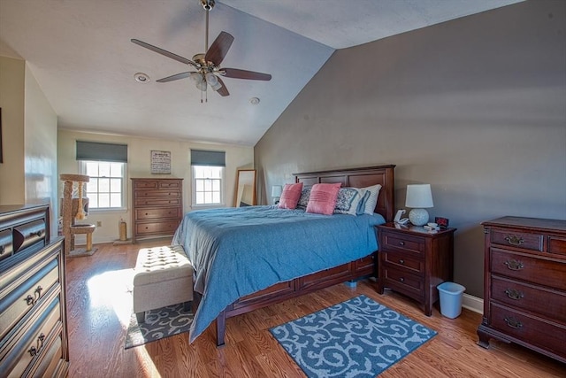 bedroom featuring ceiling fan, light hardwood / wood-style floors, and lofted ceiling