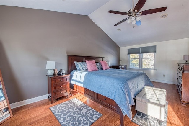 bedroom with ceiling fan, lofted ceiling, and light wood-type flooring