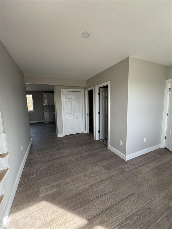 empty room with baseboards and dark wood-style flooring