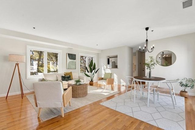 living room with a notable chandelier and light wood-type flooring