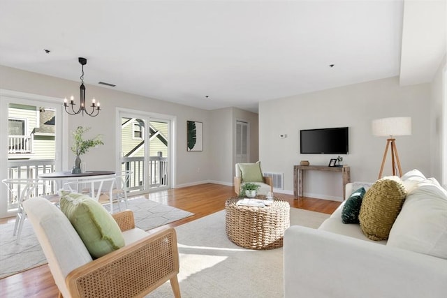 living room with an inviting chandelier and light hardwood / wood-style floors