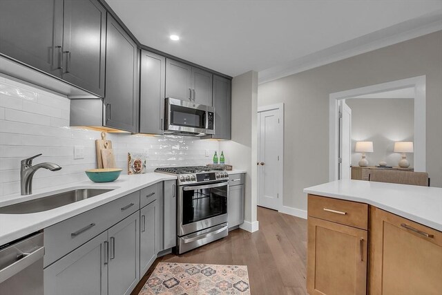 55 Pointe Pl Unit 202, Dover, NH 03820 - kitchen featuring stainless steel appliances, light countertops, tasteful backsplash, light wood finished floors, and gray cabinets