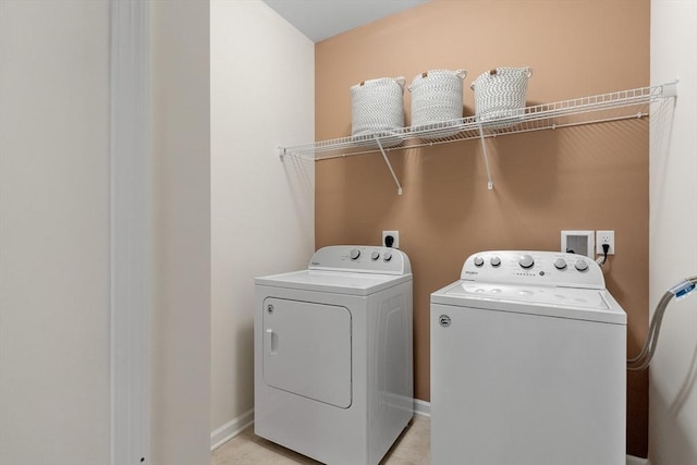 laundry room featuring light tile patterned flooring and washer and clothes dryer