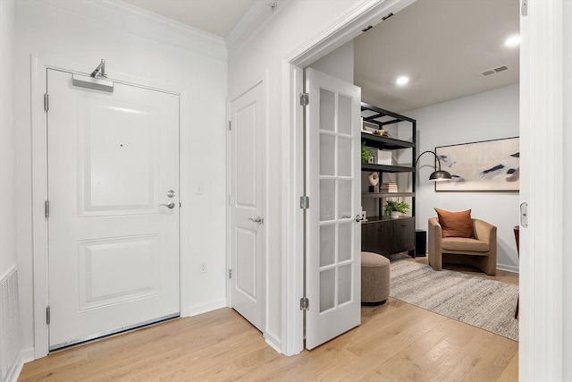 entryway featuring crown molding and light hardwood / wood-style floors