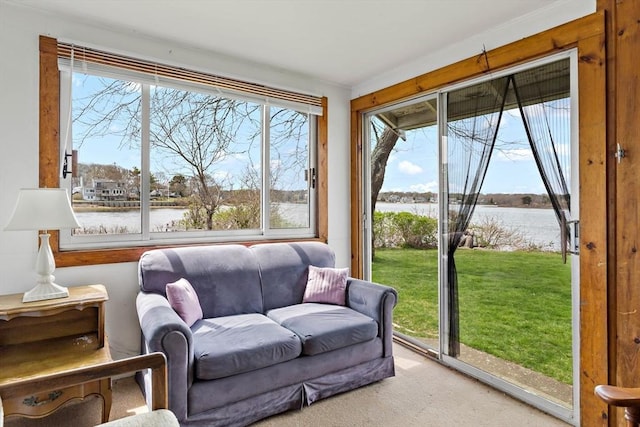 sunroom featuring a water view