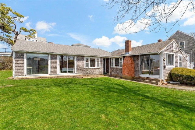 back of property featuring a chimney and a lawn