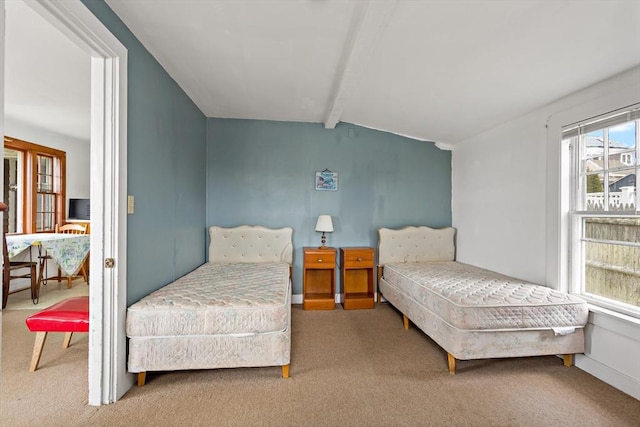 bedroom featuring lofted ceiling with beams and carpet