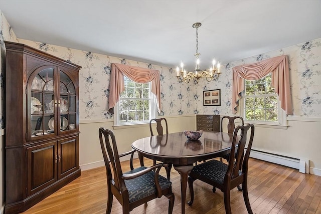 dining space featuring wallpapered walls, a notable chandelier, and a wainscoted wall