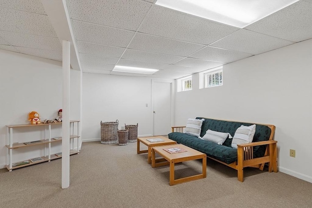 carpeted living area featuring a paneled ceiling