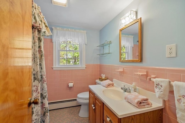 bathroom featuring visible vents, vanity, toilet, tile walls, and a baseboard radiator