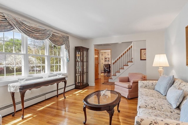 living area featuring plenty of natural light, a baseboard radiator, and light wood-style floors