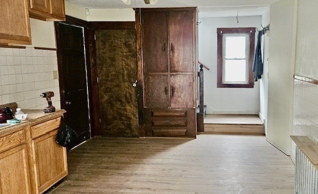 kitchen with tile walls and light hardwood / wood-style floors