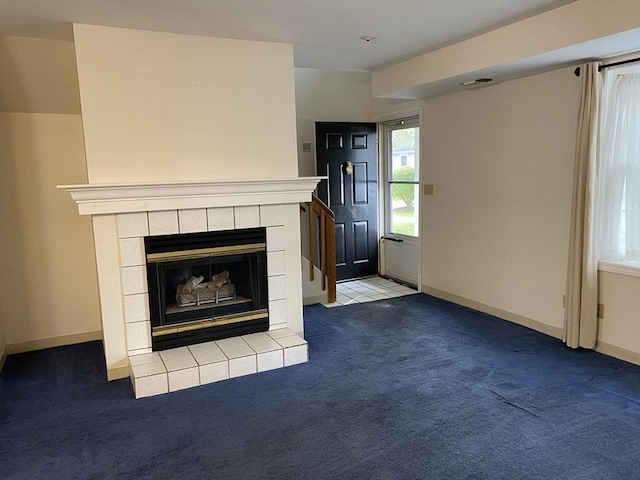 unfurnished living room featuring carpet, visible vents, baseboards, and a tile fireplace