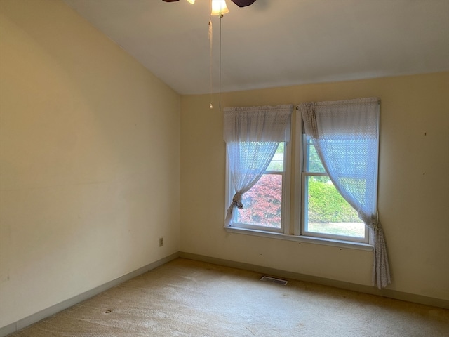 empty room featuring visible vents, ceiling fan, light carpet, and baseboards