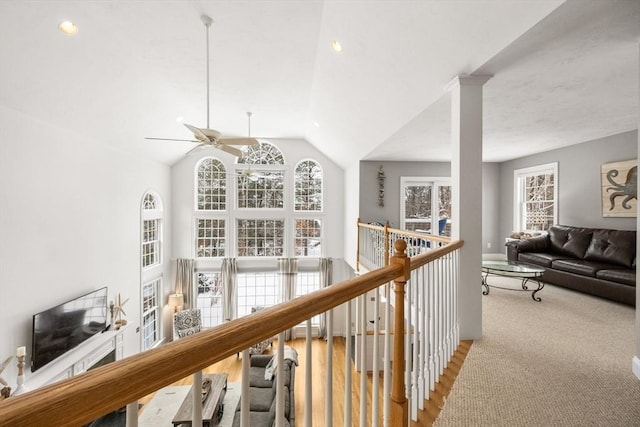 hallway featuring an upstairs landing and vaulted ceiling