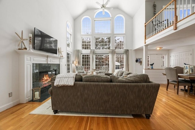 living room with a high end fireplace, plenty of natural light, and wood finished floors