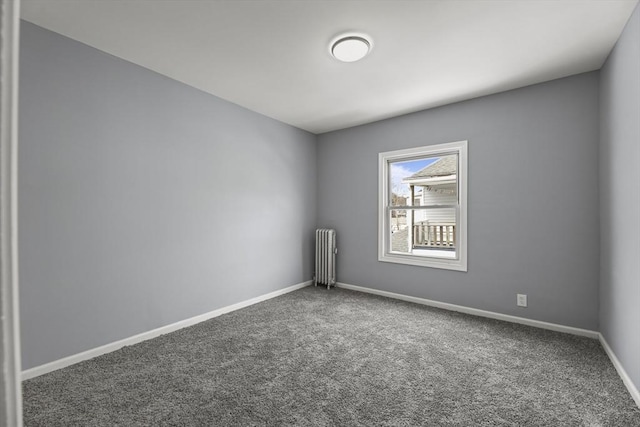 empty room featuring dark carpet and radiator heating unit