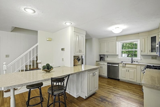 37 Eastview Rd, Hopkinton, MA 01748 - kitchen featuring dishwasher, a sink, light countertops, a textured ceiling, and a kitchen breakfast bar