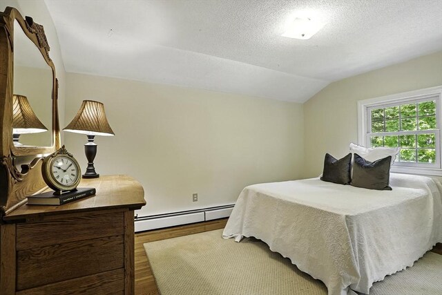 37 Eastview Rd, Hopkinton, MA 01748 - bedroom with baseboard heating, wood finished floors, lofted ceiling, and a textured ceiling