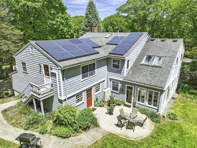 37 Eastview Rd, Hopkinton, MA 01748 - rear view of house featuring roof with shingles, a chimney, a patio area, solar panels, and french doors