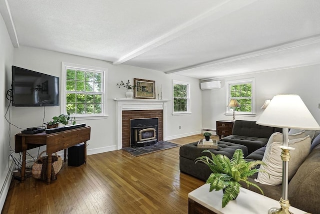37 Eastview Rd, Hopkinton, MA 01748 - living room featuring baseboard heating, dark wood-type flooring, a wood stove, baseboards, and a textured ceiling