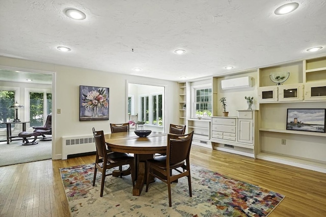 37 Eastview Rd, Hopkinton, MA 01748 - dining room featuring radiator, a wall mounted AC, light wood-type flooring, recessed lighting, and a textured ceiling