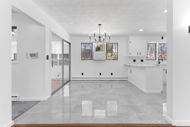 interior space featuring a chandelier, sink, and a baseboard heating unit