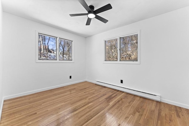 unfurnished room with ceiling fan, a baseboard radiator, and light wood-type flooring