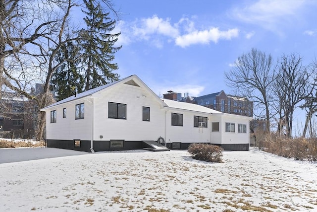 snow covered rear of property with cooling unit