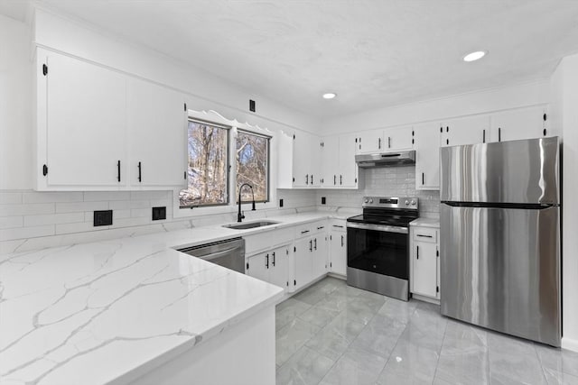 kitchen featuring white cabinetry, appliances with stainless steel finishes, sink, and light stone counters