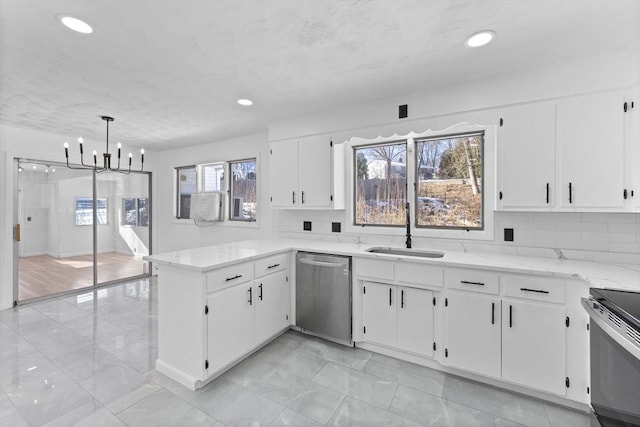 kitchen featuring appliances with stainless steel finishes, a wealth of natural light, sink, white cabinets, and hanging light fixtures