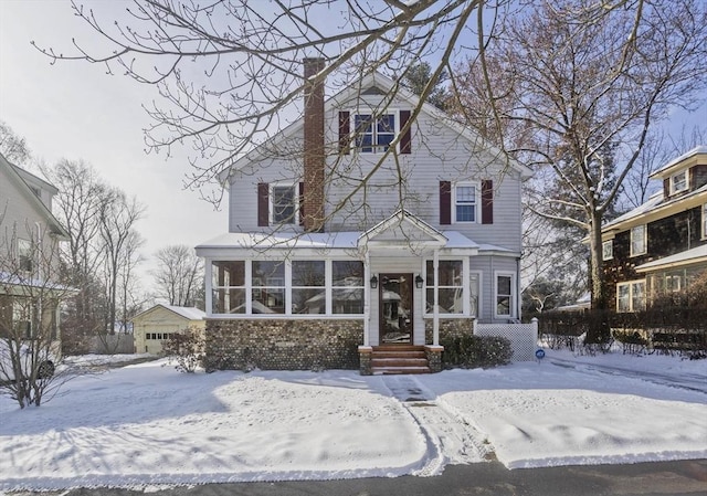 view of front of property featuring a garage and a sunroom