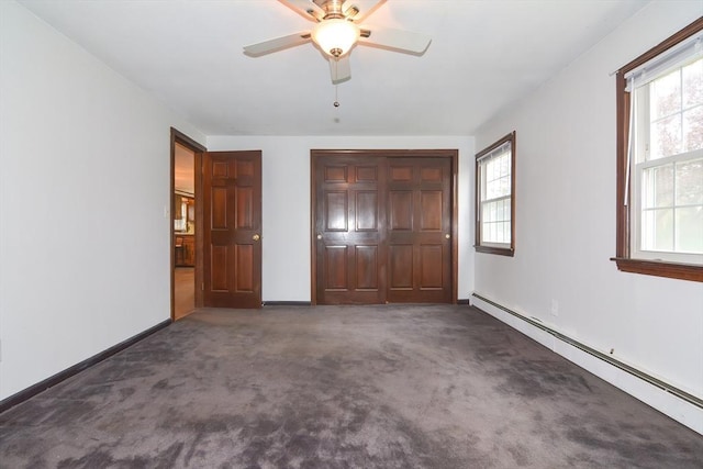unfurnished bedroom featuring a baseboard radiator, carpet, and multiple windows