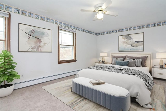 bedroom with carpet floors, a ceiling fan, and a baseboard heating unit