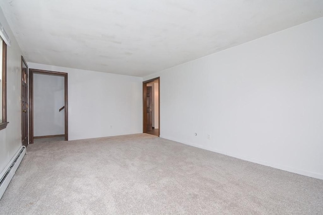 carpeted empty room with a baseboard heating unit