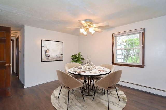 dining space with a ceiling fan, baseboards, wood finished floors, and a baseboard radiator