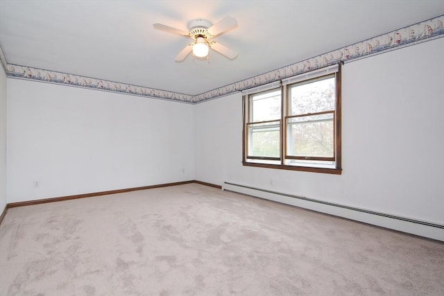 carpeted spare room with a ceiling fan, baseboards, and a baseboard heating unit