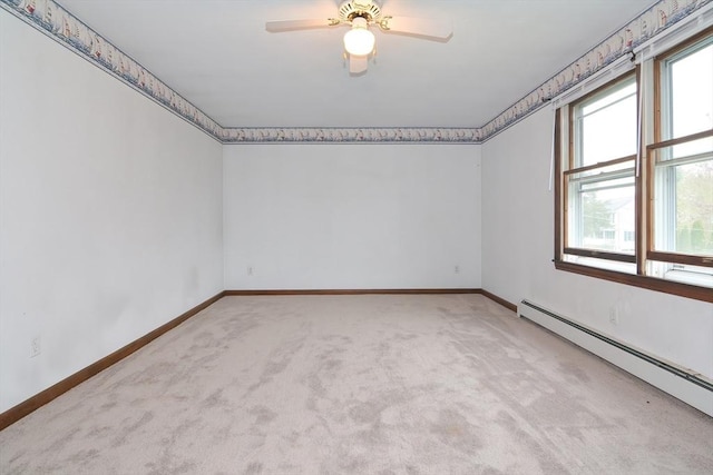 carpeted spare room with baseboards, a ceiling fan, and a baseboard heating unit