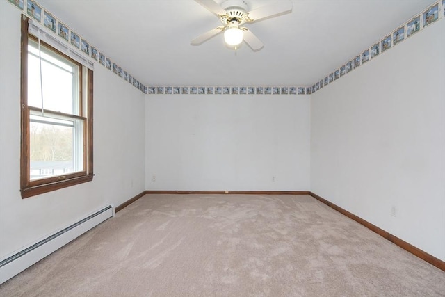 empty room featuring carpet floors, ceiling fan, baseboard heating, and a healthy amount of sunlight