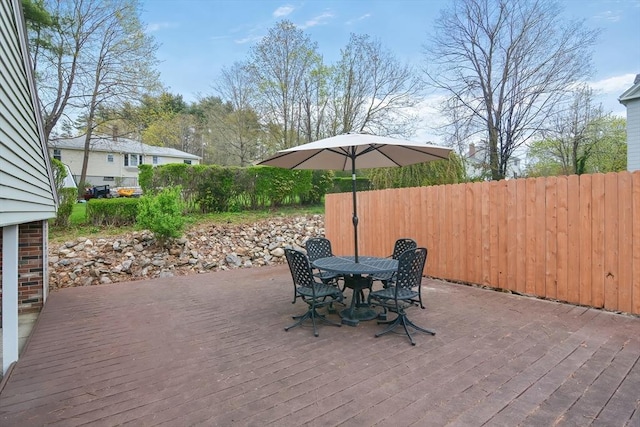 view of patio / terrace featuring fence, a deck, and outdoor dining space