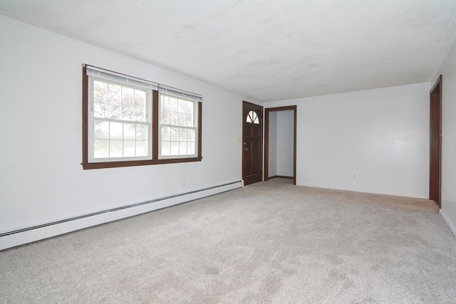 carpeted empty room with a baseboard heating unit