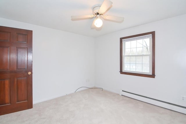carpeted spare room featuring baseboards, ceiling fan, and a baseboard heating unit