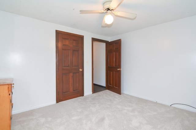 unfurnished bedroom with baseboards, ceiling fan, and carpet