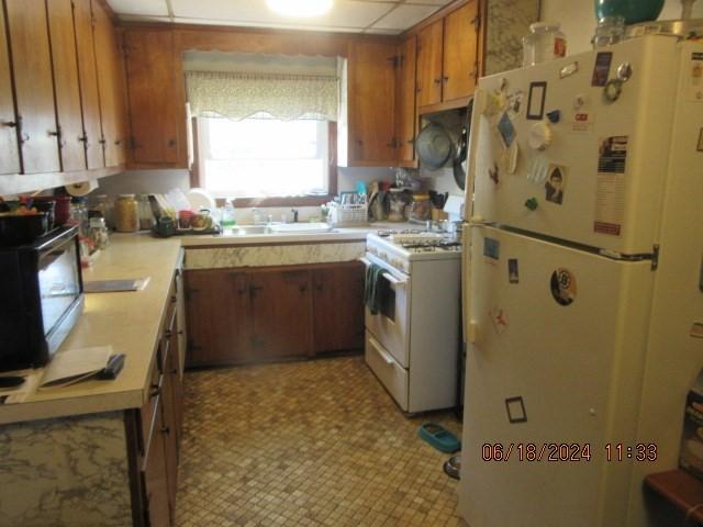 kitchen featuring white appliances and sink