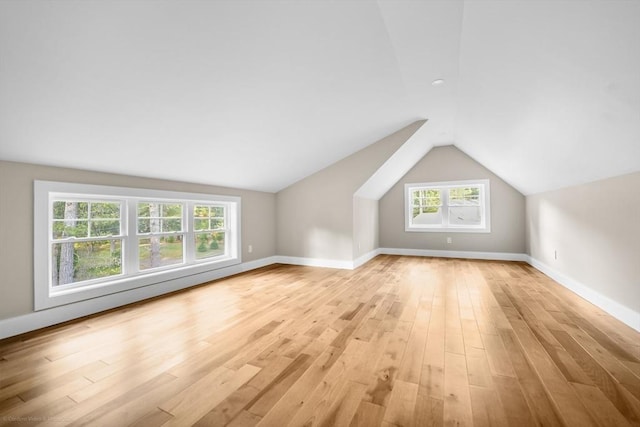 bonus room featuring baseboards, vaulted ceiling, and light wood-style flooring