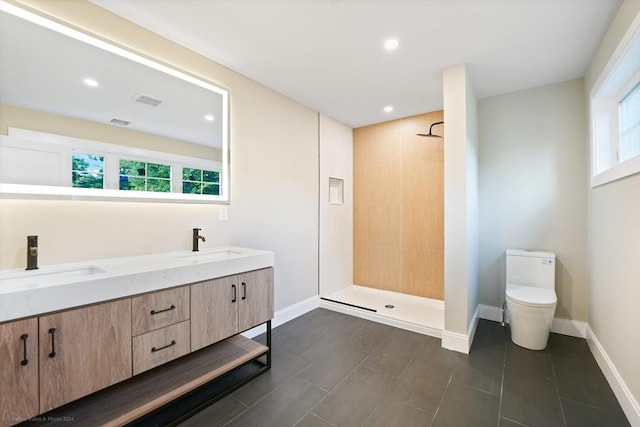 full bathroom with a sink, toilet, and tiled shower