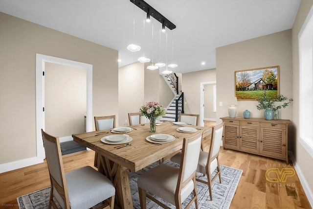 dining room featuring baseboards, recessed lighting, light wood-style flooring, and stairs