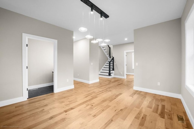 unfurnished living room with recessed lighting, stairway, baseboards, and light wood finished floors
