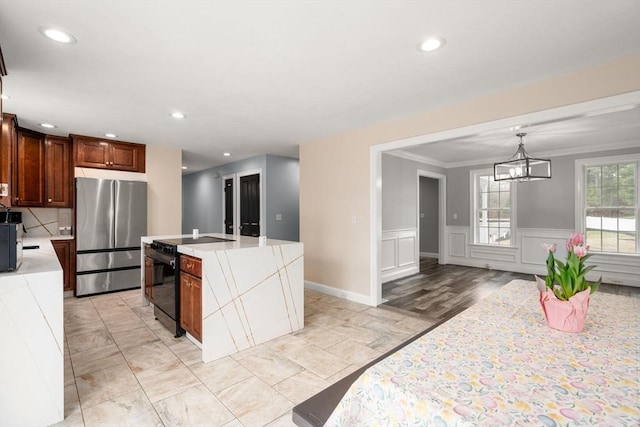 2 Britlees Way, Dudley, MA 01571 - kitchen featuring freestanding refrigerator, light countertops, a chandelier, black / electric stove, and a kitchen island with sink